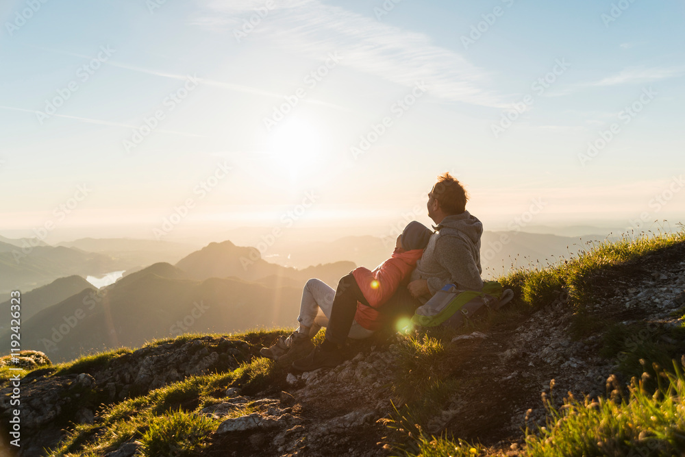 Couple sitting and looking at view on mountain Couple sitting and looking at view on mountain
