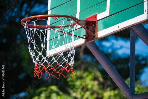 Outdoor Basketball Hoop with Green Wooden Backboard and Blue Sky Background, Perfect for Recreational Sports and Exercise Enthusiasts