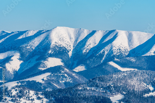 Velka Chochula and Prasiva hills in westernmost part of Low Tatras mountains from Ploska hill in Velka Fatra mountains in Slovakia during winter photo
