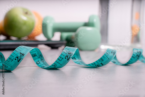 tape measure in the foreground and fruit and a body weight scale in the background