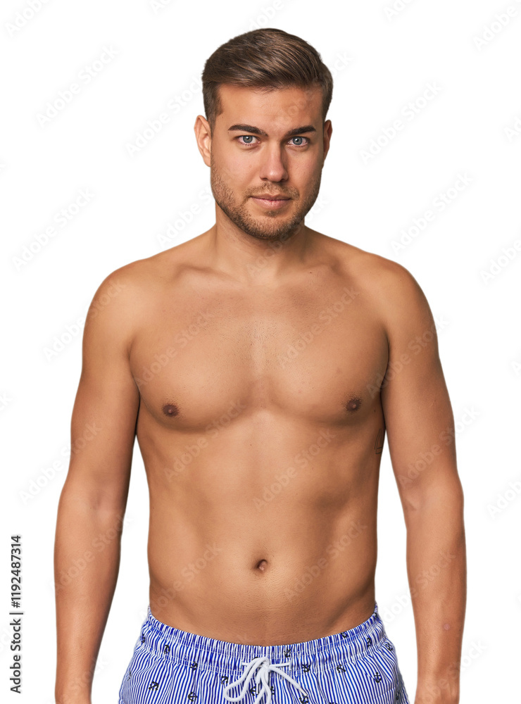 Fototapeta premium Shirtless young man in swimsuit against a studio backdrop, embodying summer vibes