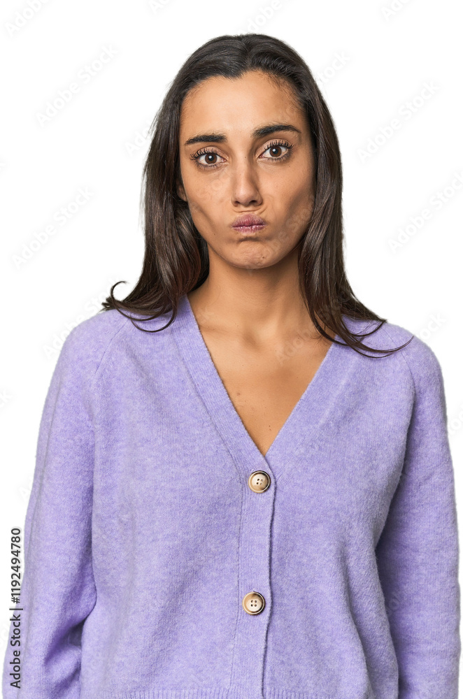 Hispanic young woman blows cheeks, has tired expression. Facial expression concept. Hispanic young woman blows cheeks, has tired expression. Facial expression concept.