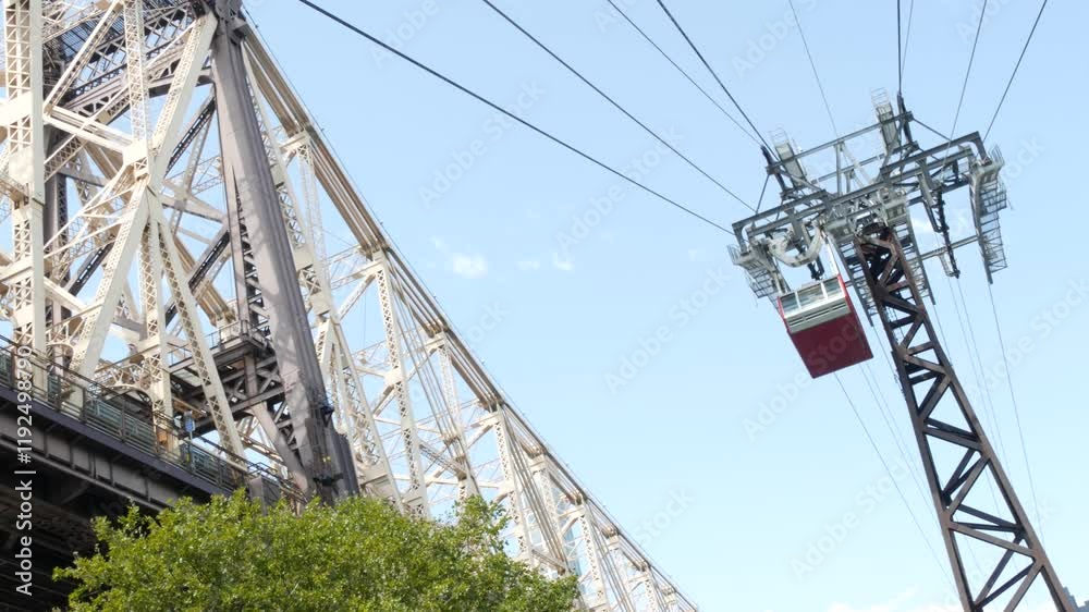 New York City Roosevelt Island tramway to Manhattan Midtown. American aerial cable tram near Queensboro Bridge. Urban public passenger transport, USA. Transportation and architecture in United States. New York City Roosevelt Island tramway to Manhattan Midtown. American aerial cable tram near Queensboro Bridge. Urban public passenger transport, USA. Transportation and architecture in United States.