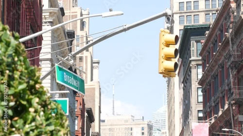 Broadway street road sign, Manhattan midtown property, house architecture, New York City real estate. Yellow traffic light and roadsign on crossroad. Historic district intersection, United States.