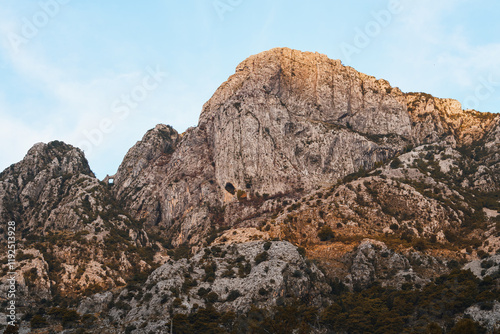 Sunlit mountains by calm lake scene