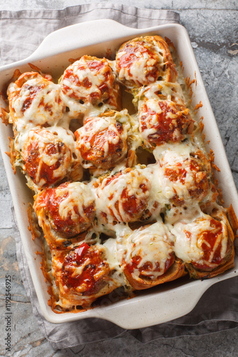 Obraz na płótnie Meatball Stuffed Garlic Bread Sliders topped with cheese closeup on the baking dish on the table. Vertical top view from above w salonie