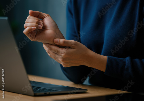 Woman experiencing wrist pain while working on laptop