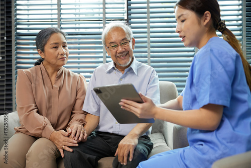nurse or caregiver meeting and talking with about health with senior couple