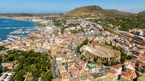 Aerial view of the Flavian Amphitheater, located in the historic center of Pozzuoli, near Naples, Italy. In the background is the Mediterranean Sea,.