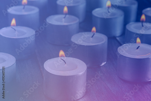 Tea light candles on a dark background, many lights in the dark, candlelight, toned image