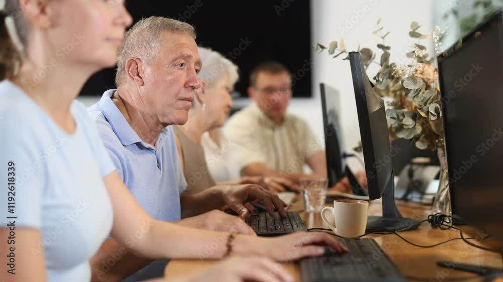Elderly man learns to use computer in group at master class Elderly man learns to use computer in group at master class