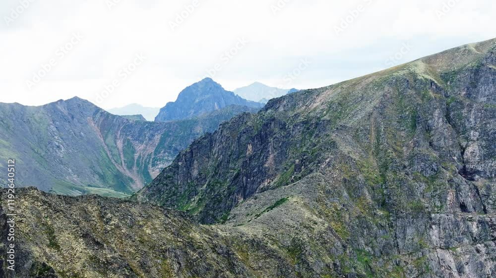 A stunning drone shot of an epic mountain valley in summer, featuring lush green meadows and towering peaks under a vibrant blue sky. A stunning drone shot of an epic mountain valley in summer, featuring lush green meadows and towering peaks under a vibrant blue sky.