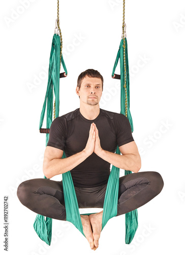 Caucasian adult male practicing aerial yoga in hammock with meditative pose photo