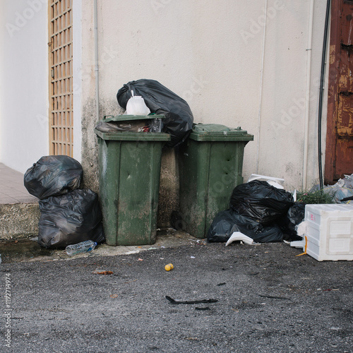 Photos Uncollected garbage on a road next to a building