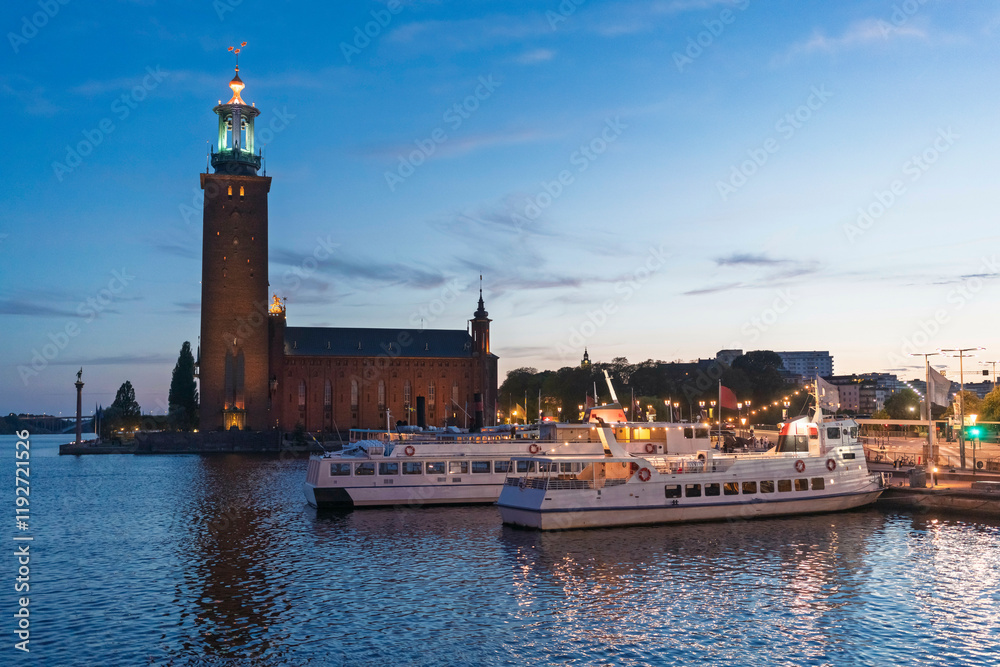 Sunset view of Stockholm City Hall with boats moored in the foreground and a clear evening sky, Stockholm, Sweden Sunset view of Stockholm City Hall with boats moored in the foreground and a clear evening sky, Stockholm, Sweden