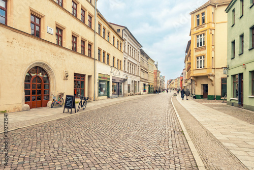 Cobblestone street in the old city of Luther City of Wittenberg with historical buildings and pedestrians, Lutherstadt Wittenberg photo