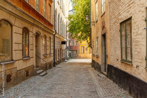 Cobblestone street in in Gamla Stan old city in Stockholm, Sweden at sunrise with historic buildings and no pedestrians. photo