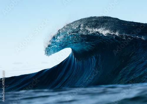 Majestic ocean wave cresting in the open sea at sunrise photo