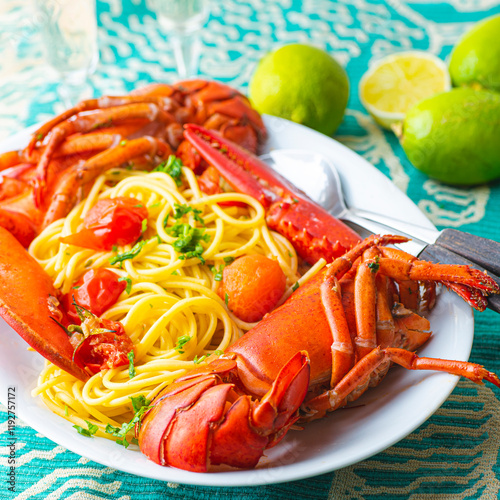 Lobster linguine pasta served with tomatoes and fresh lemons. Delicatessen, rare seafood pasta recipe. Sardinia, Sicilian, Neapolitan cuisine. Italian and French, Nord America  recipe. Square crop photo