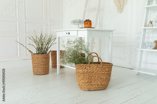 Spring skandi decor in interior design of white kitchen. Provence. Stylish easter rustic home decor - wicker basket with branches blooming willow, easter cake on wooden table, bouquet Gypsophila.	
 photo