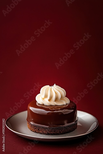 Decadent chocolate Sacher torte with apricot jam and whipped cream on silver plate against crimson backdrop