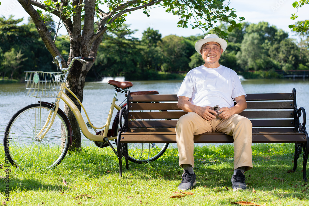 Peaceful Lakeside Moment: A relaxed senior man sits on a park bench, enjoying a sunny day by the lake with his bicycle nearby. A tranquil scene of serenity and leisure. Peaceful Lakeside Moment: A relaxed senior man sits on a park bench, enjoying a sunny day by the lake with his bicycle nearby. A tranquil scene of serenity and leisure.