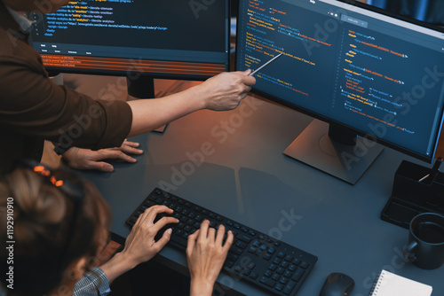 Top view of IT developers discussing with point to intelligent website development coder system running data online two screens information technology at neon light room at modern office. Infobahn. photo