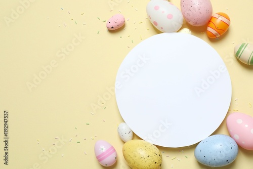 Colorful eggs, sweet sprinkles and paper card on pastel beige backdrop,  space for your text or advertisement photo