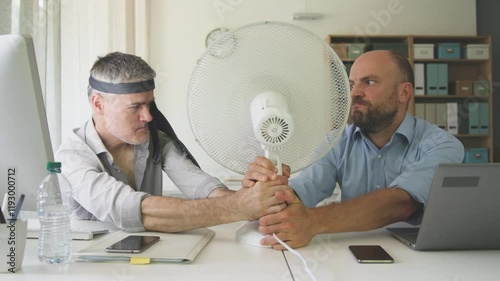 Office workers fighting over the electric fan