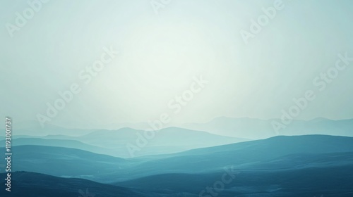 A calming view of distant hills fading into a soft blue horizon, beautifully illustrating the transition from earth to sky and evoking a sense of serenity. photo