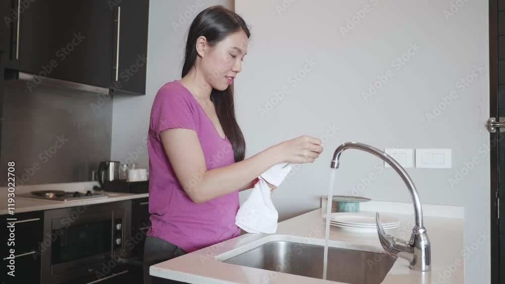 A woman is washing dishes in a modern kitchen, showcasing a clean and organized space. This image captures the essence of daily life and home hygiene. A woman is washing dishes in a modern kitchen, showcasing a clean and organized space. This image captures the essence of daily life and home hygiene.