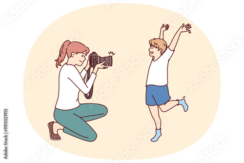 Photographer mother and little boy make professional photoshoot to capture happy moments from childhood. Son happily poses for female child photographer preparing family photo album