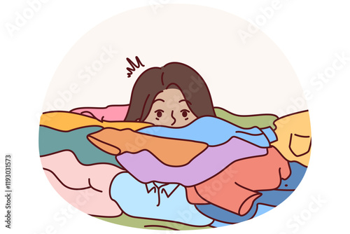 Face of woman near dirty clothes in need of washing with colored laundry detergent. Girl housewife or maid drowns in dirty linen due to overwork and overload with household chores.