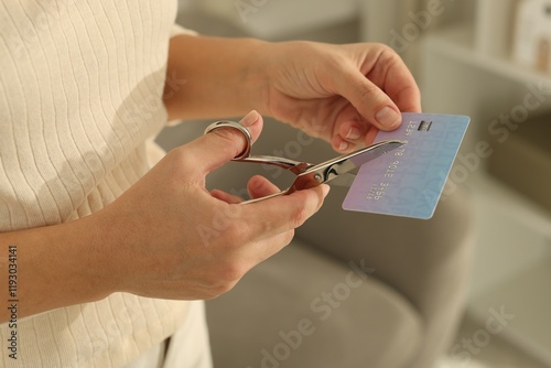 Woman cutting plastic credit card indoors, closeup photo