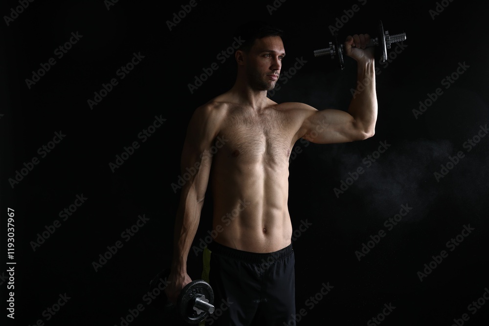 Man training with barbell on black background