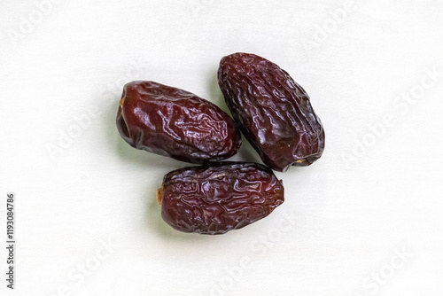 Three fresh, dried dates isolated on a white background. Top view. photo