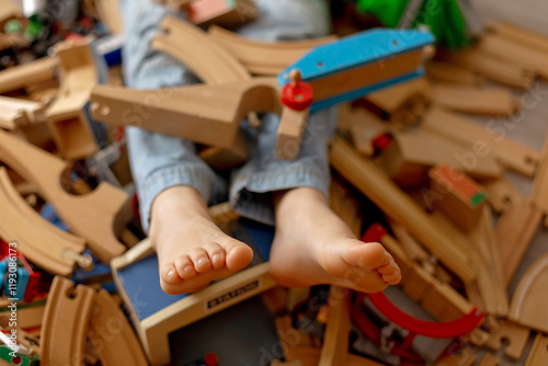 Child, cute boy, playing with toys in a playroom, focus on his feet