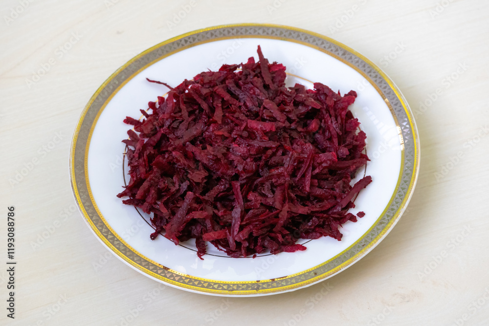 Thinly sliced or grated beetroot fritters are presented on a white ceramic plate against a light wooden backdrop. Perfect for a healthy diet. Thinly sliced or grated beetroot fritters are presented on a white ceramic plate against a light wooden backdrop. Perfect for a healthy diet.