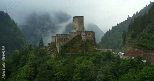 4K aerial video capturing a medieval castle enveloped by a foggy forest, highlighting the mysterious ambiance and ancient architecture amidst the dense woodland. Rize, Turkey
