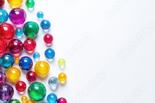 Colorful glass marbles scattered on white surface create vibrant