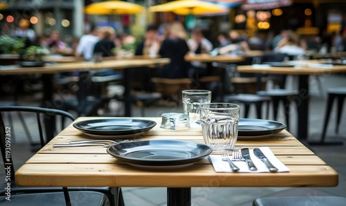 Outdoor cafe table setting with blurred diners in background