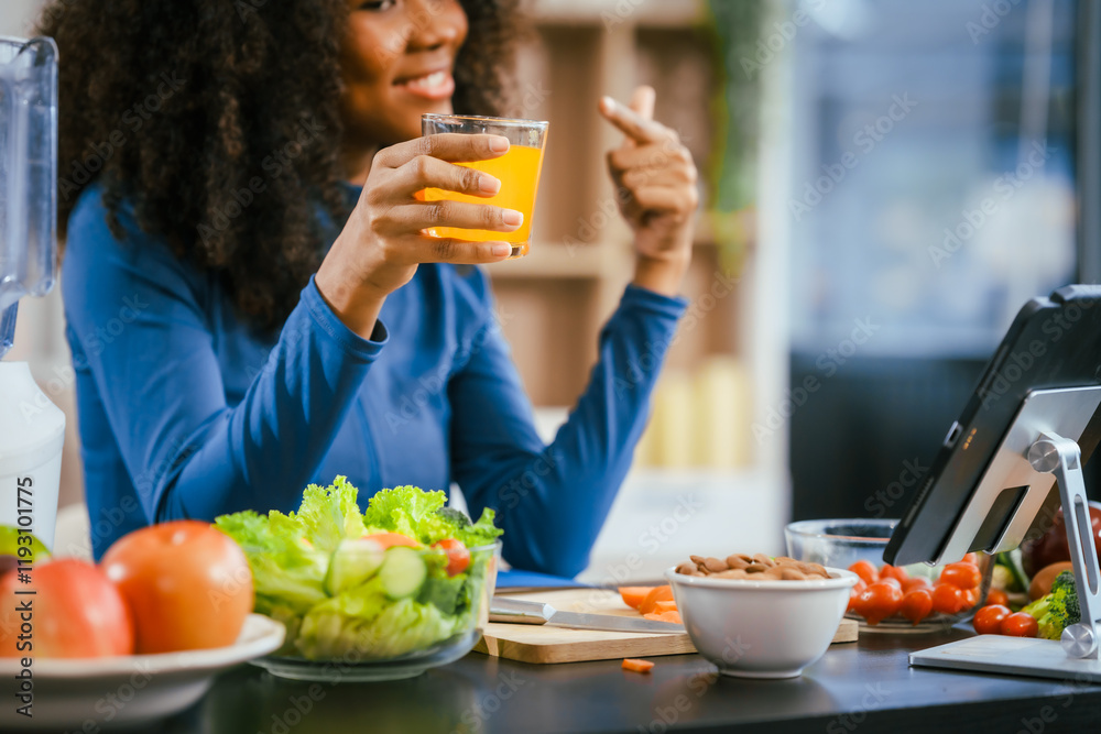 African American woman sitting table, enjoying a colorful salad orange juice, highlighting the health benefits of five-color fruits vegetables, rich in antioxidants, reducing cancer risks,wellness African American woman sitting table, enjoying a colorful salad orange juice, highlighting the health benefits of five-color fruits vegetables, rich in antioxidants, reducing cancer risks,wellness