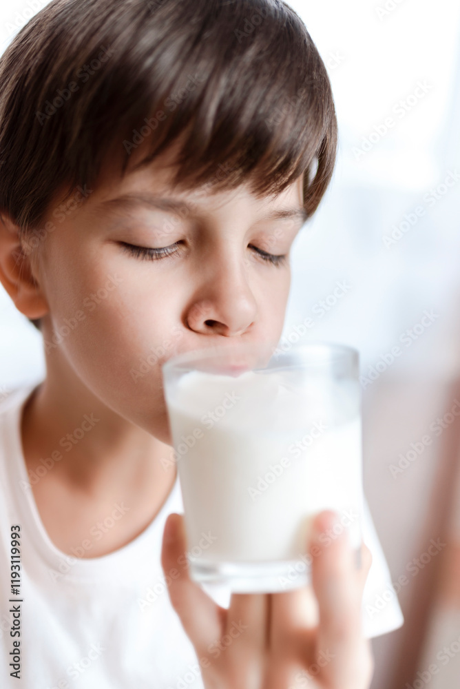 Cute boy drinking milk from a glass at home Cute boy drinking milk from a glass at home