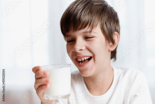 Cute boy holding a glass of milk and smiling