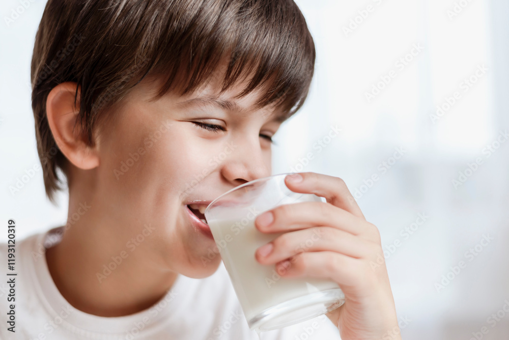 Cute boy drinking milk at home and smiling on white background Cute boy drinking milk at home and smiling on white background