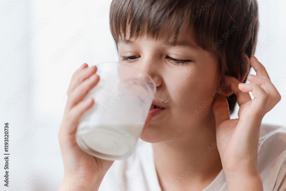 Cute boy drinking milk from a glass at home Cute boy drinking milk from a glass at home