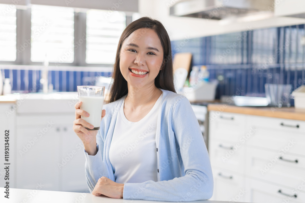 Health care asian young woman, cute girl holding a glass of white fresh, dairy cow milk to drink for calcium, vitamin wholesome good nutrition in morning at kitchen home, product of healthy people. Health care asian young woman, cute girl holding a glass of white fresh, dairy cow milk to drink for calcium, vitamin wholesome good nutrition in morning at kitchen home, product of healthy people.
