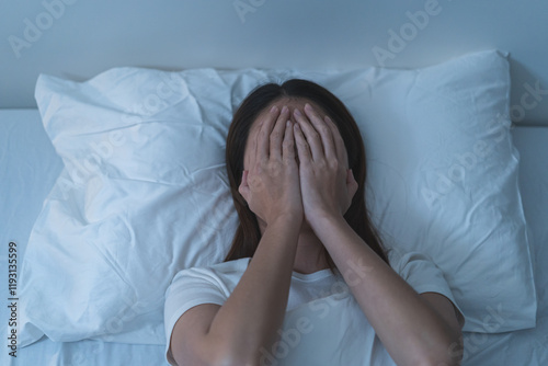 Stressed can not sleep asian young woman, girl use hand to cover her face on bed at home, suffering from insomnia, awake at night in bedroom, tired. Frustrated with problem, exhausted on nightmares.