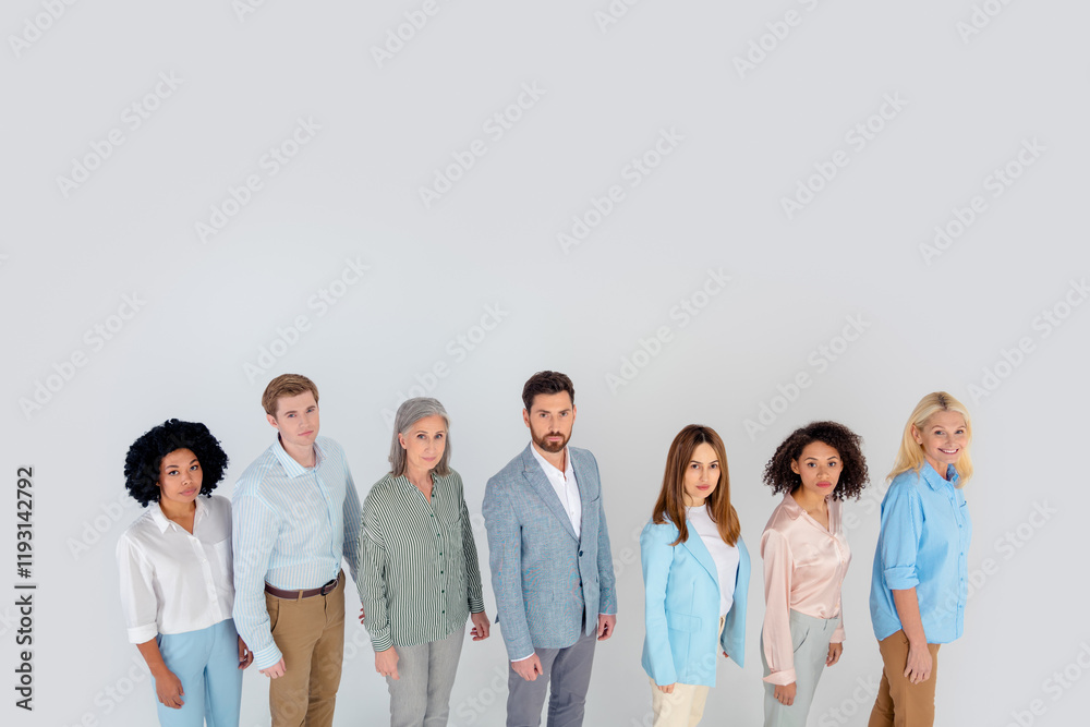 Diverse group of coworkers standing together on grey background showcasing professional business attire and teamwork, top view Diverse group of coworkers standing together on grey background showcasing professional business attire and teamwork, top view