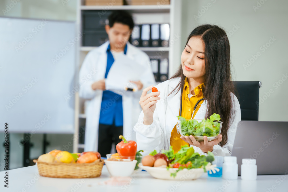 Two nutritionists,female and male, work in a hospital, analyzing vegetable and fruit salads, offering online advice, helping patients embrace clean eating habits and weight control for better health Two nutritionists,female and male, work in a hospital, analyzing vegetable and fruit salads, offering online advice, helping patients embrace clean eating habits and weight control for better health